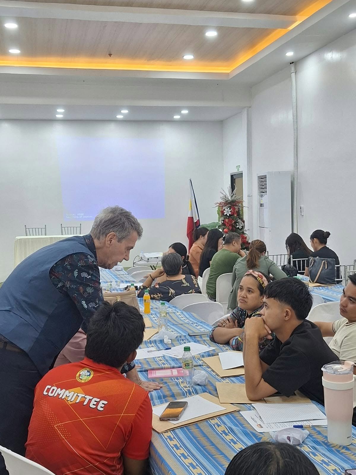 A facilitator speaking with participants around a seminar table