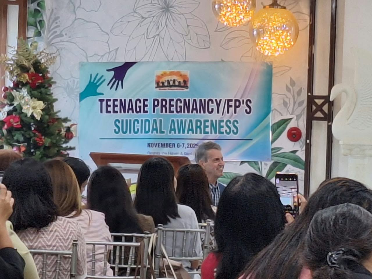 Audience seated near a seminar banner on teenage pregnancy and suicide awareness